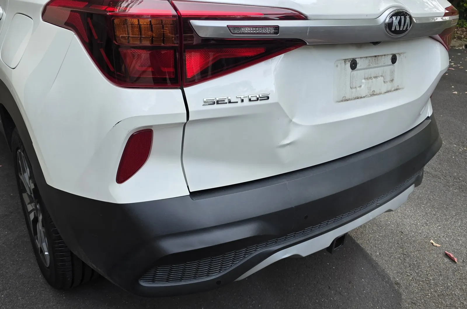 White SUV tailgate dent before repair