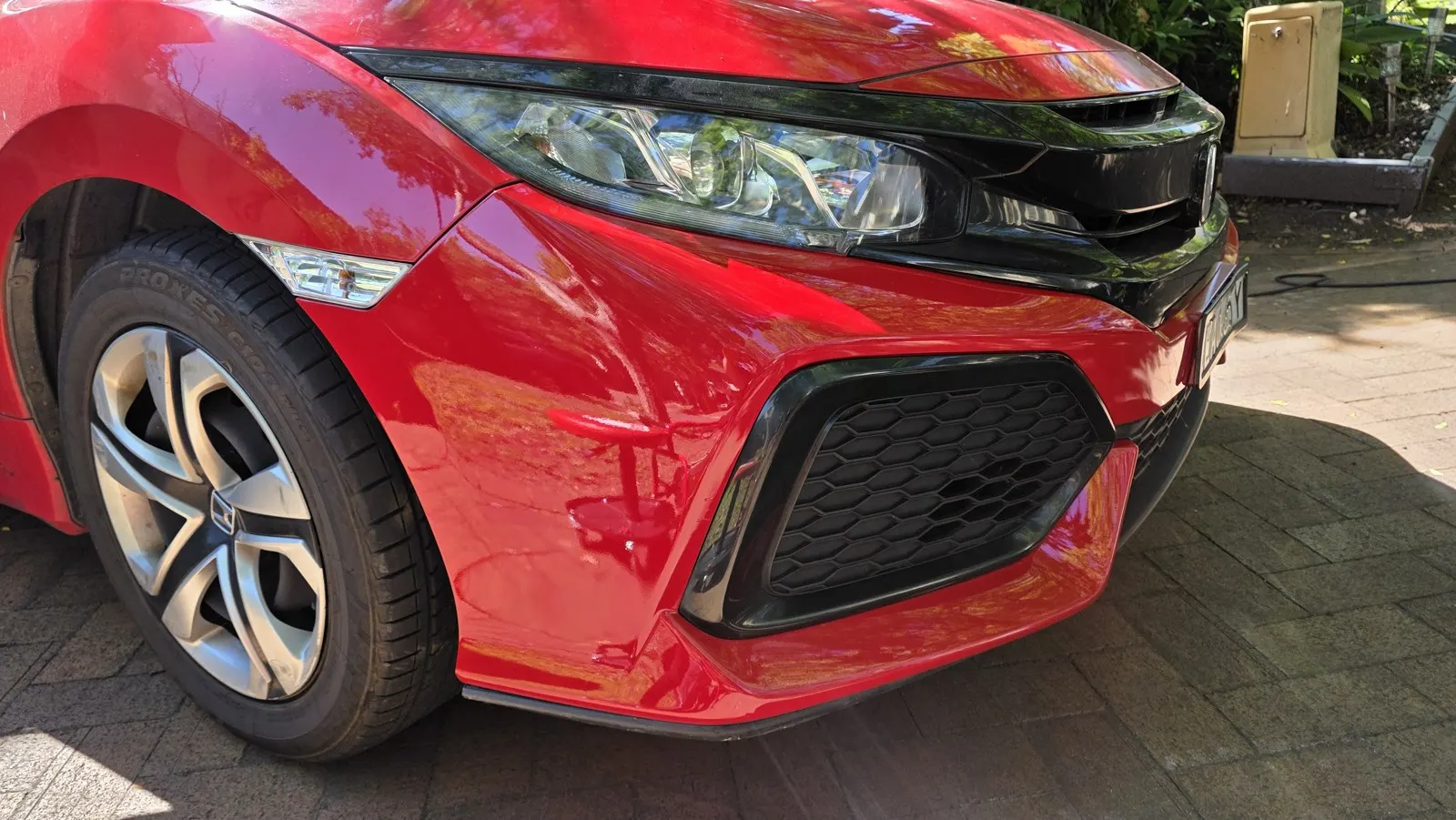 Red car bumper scuffs after repair