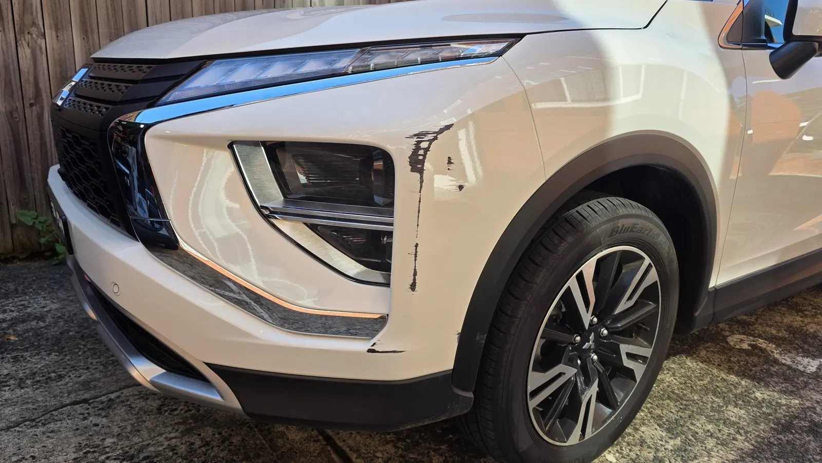 White SUV bumper repair before repair