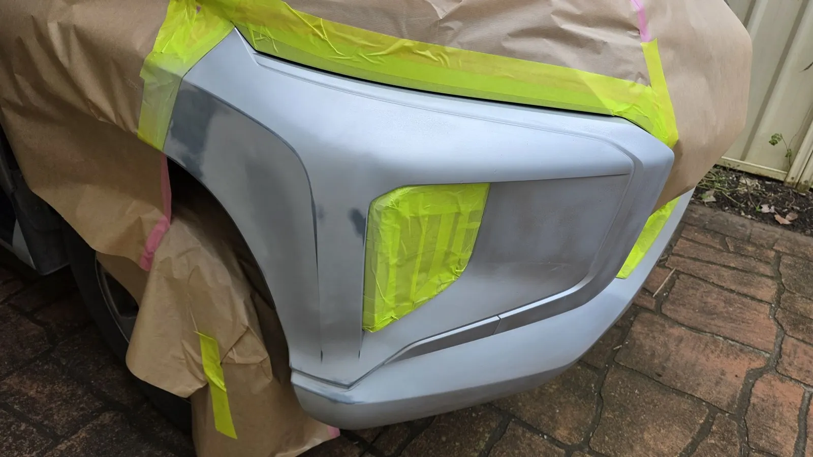 Silver SUV bumper refinishing before repair