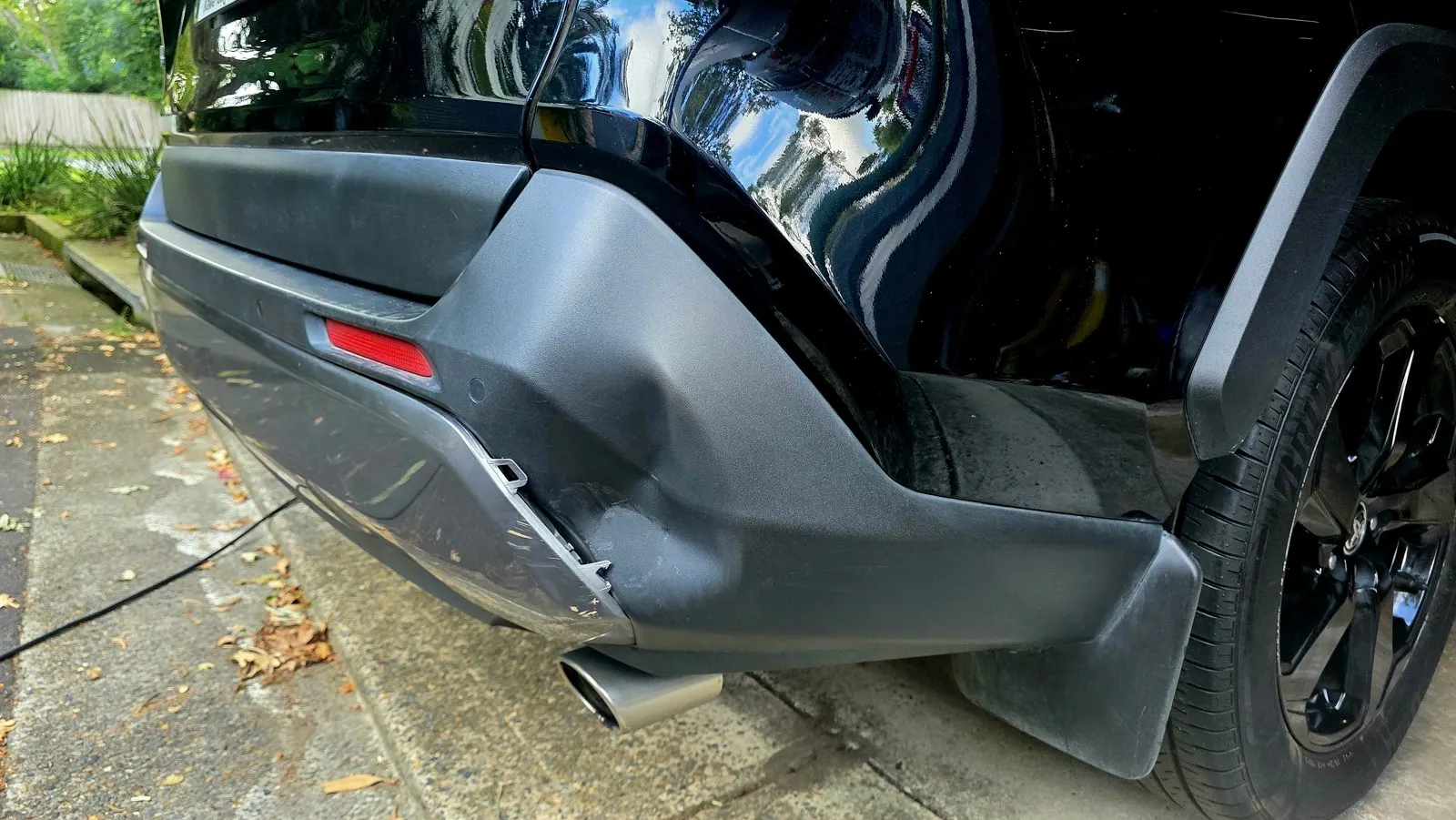 Black SUV rear bumper repair before repair