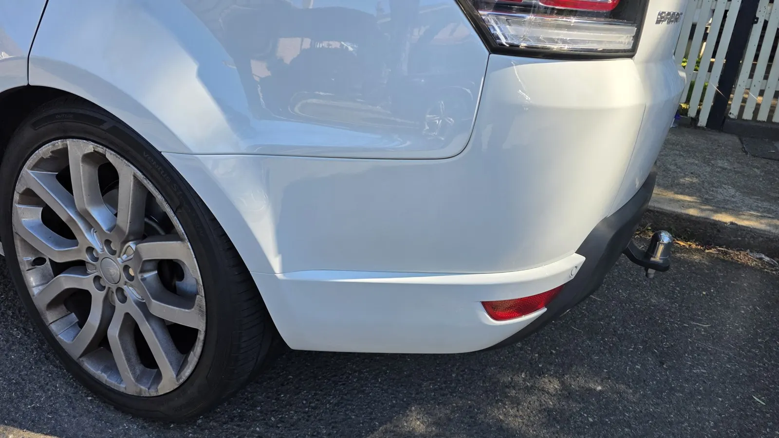 Silver vehicle rear bumper scuffs before repair
